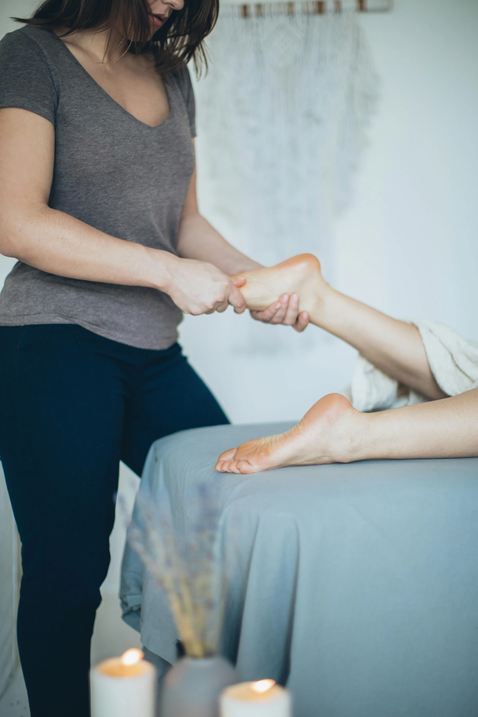 a woman getting a foot massage at a spa, unsplash, paul barson, caucasian, full - length photo, unhappy