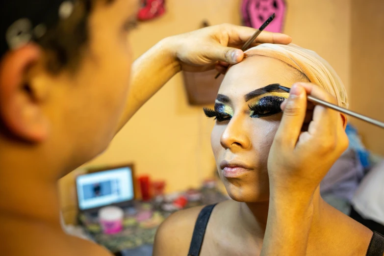 a woman is getting her make up done, by Gina Pellón, pexels contest winner, photorealism, ru paul\'s drag race, egypt makeup, black eyebrows, production photo