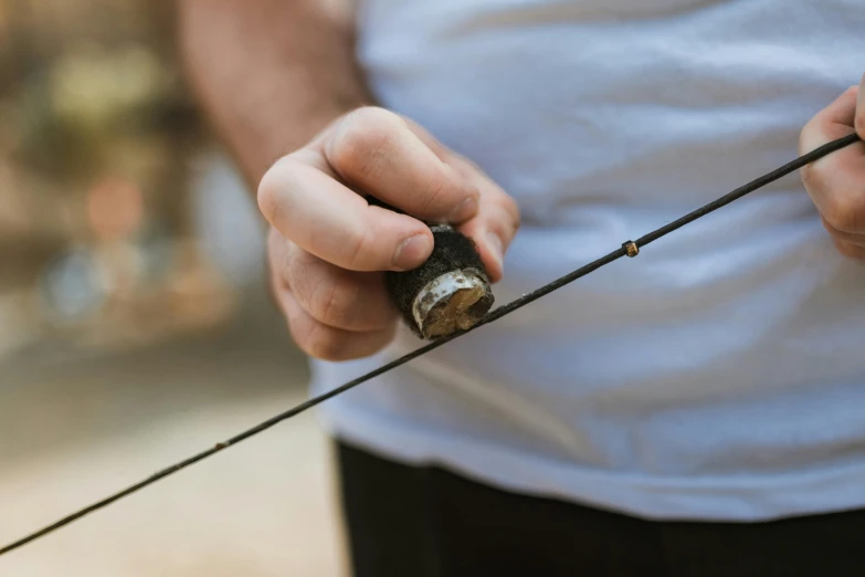 a close up of a person holding a fishing rod, unsplash, renaissance, clutch yo - yo, high quality detail, exterior shot, worn