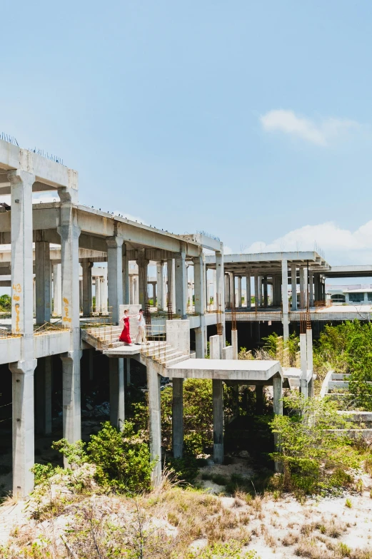 a couple of people standing on top of a bridge, inspired by Tadao Ando, unsplash, brutalism, puerto rico, abandoned shopping mall, “wide shot, under construction