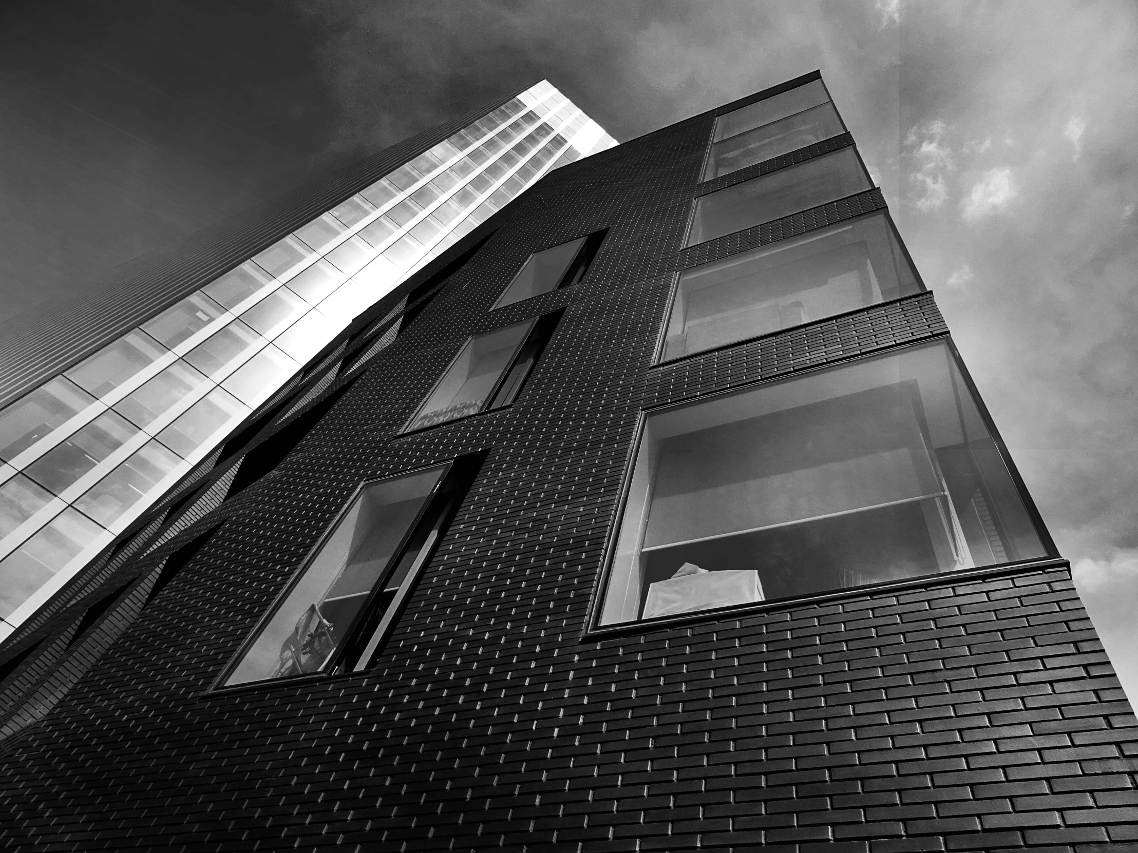 a black and white photo of a tall building, by Patrick Pietropoli, unsplash, brick building, full of glass. cgsociety, black house, monochrome 3 d model