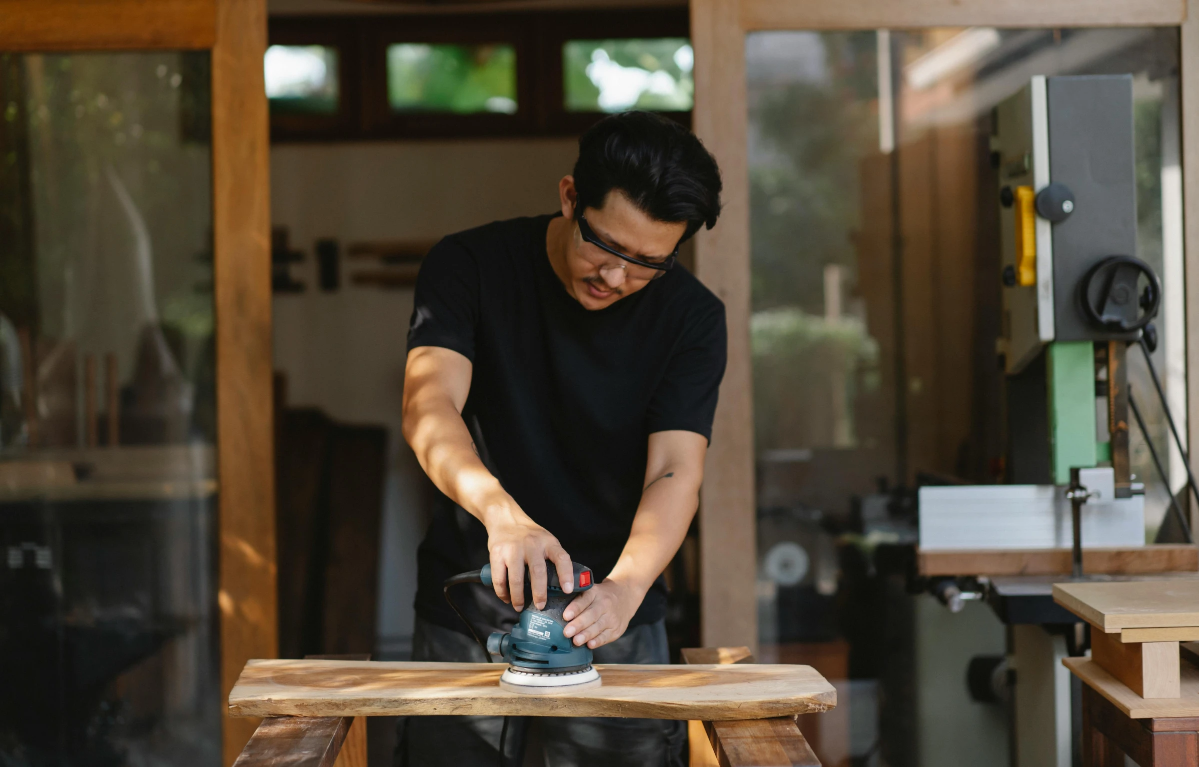 a man sanding a piece of wood with a machine, inspired by Miyagawa Chōshun, pexels contest winner, shin hanga, avatar image, plating, ross tan, focus on full - body