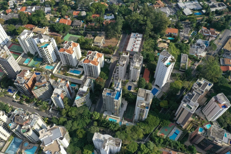 an aerial view of a city with lots of tall buildings, by Felipe Seade, modernism, empty buildings with vegetation, salvador, thumbnail, less detailing