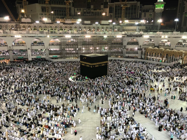 a large crowd of people standing around a building, a picture, by Benjamin Block, pexels, hurufiyya, mecca, 2 5 6 x 2 5 6 pixels, inside a grand, bl