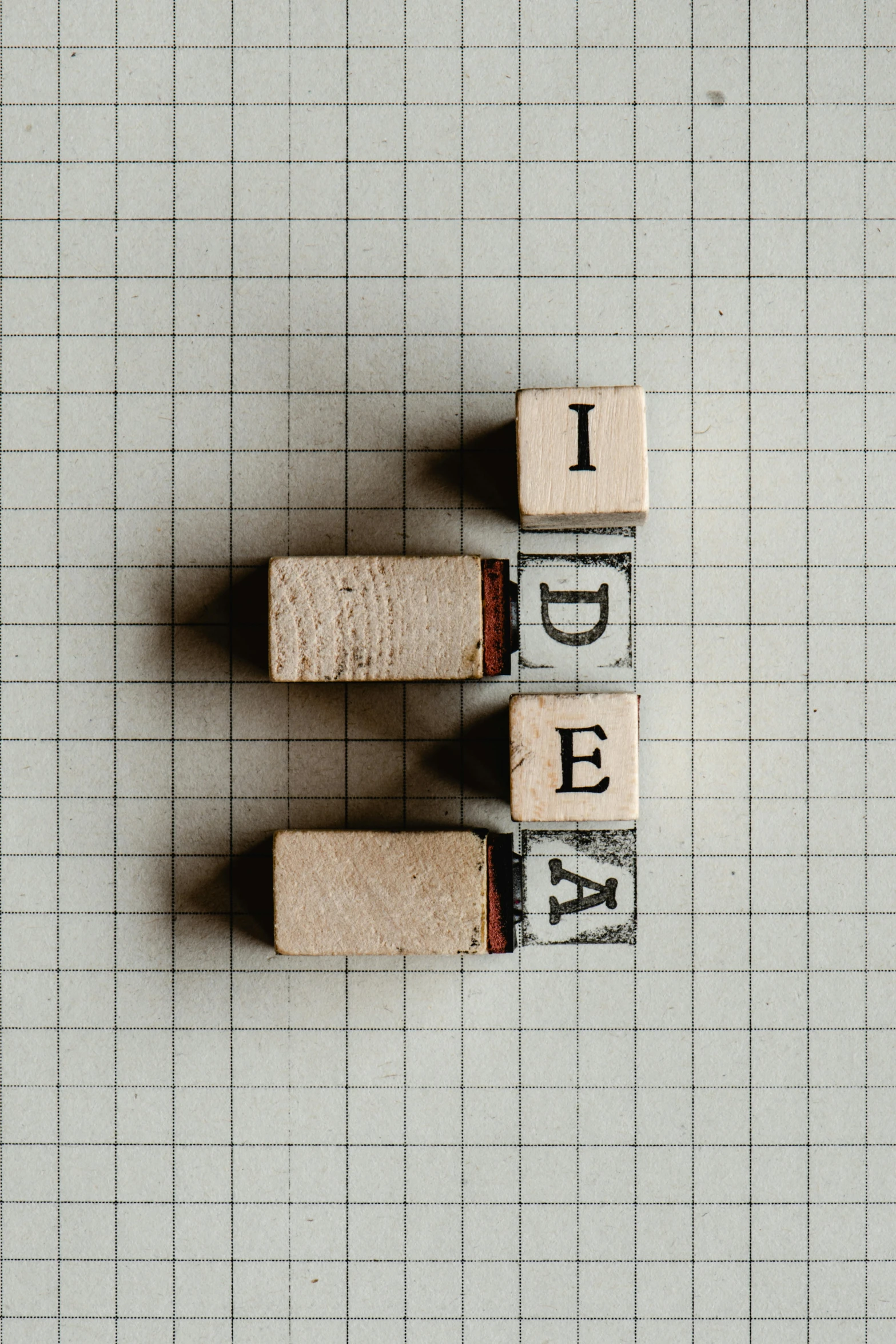 a couple of wooden letters sitting on top of a piece of paper, an inventor, the idea, abstract blocks, unsplash transparent