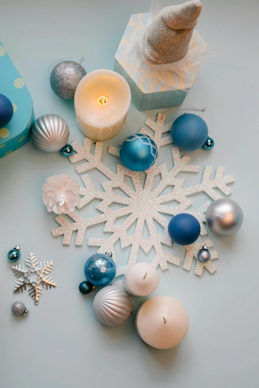 a table topped with christmas ornaments and candles, a still life, trending on pexels, white and blue color scheme, top - down view, ilustration, ornament