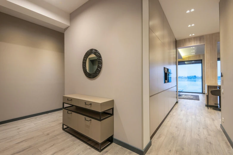 an empty hallway with a mirror on the wall, a picture, by Carlo Martini, lacquered oak reception desk, professional studio, seaview, floor b2