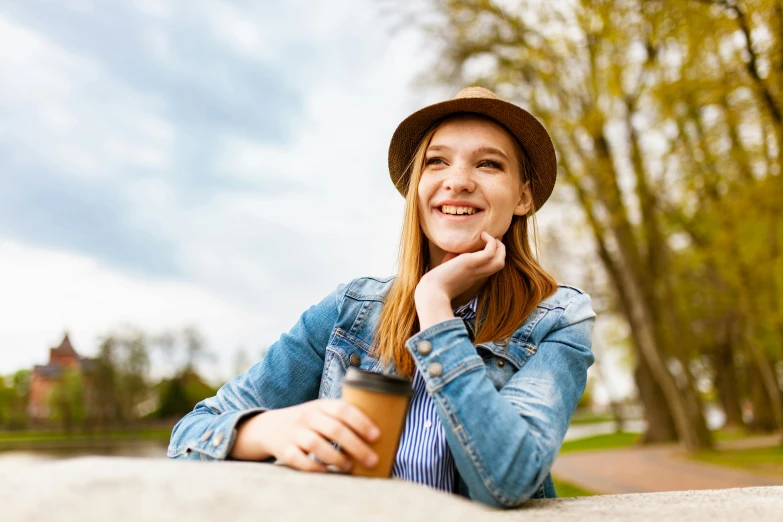 a beautiful young woman holding a cup of coffee, trending on pexels, avatar image, at the park on a beautiful day, 15081959 21121991 01012000 4k, brown hat