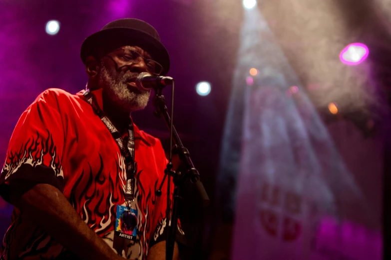 a man that is standing in front of a microphone, funkadelic, old gigachad with grey beard, shot with sony alpha, reds