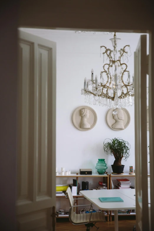 a living room filled with furniture and a chandelier, a marble sculpture, inspired by Reinier Nooms, pinterest, close up portrait shot, doorway, ceramic statue, shot with hasselblade camera