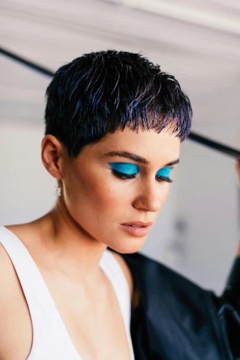 a woman with blue eyes holding an umbrella, an album cover, inspired by Marie-Gabrielle Capet, trending on pexels, pixie undercut black hair, teal palette, unreal engine : : rave makeup, evening makeup