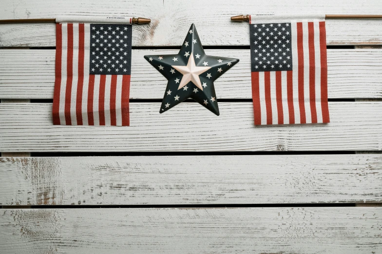 two american flags hanging on a wooden wall, pexels, stars, background image, enamel, miscellaneous objects