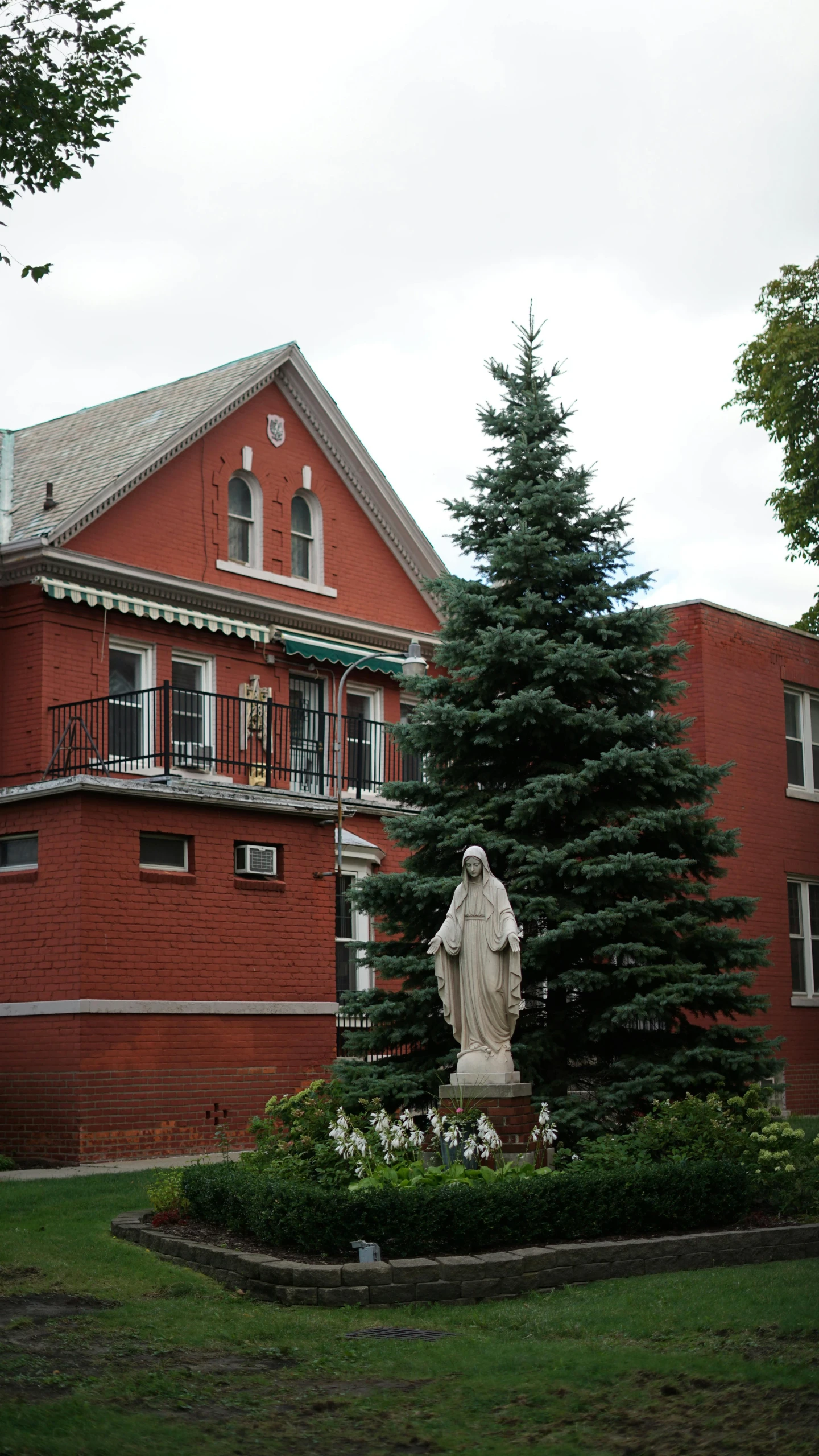 a red building with a statue in front of it, a statue, by Everett Warner, heidelberg school, virgin mary, ( greg rutkowski ), trending photo, 15081959 21121991 01012000 4k