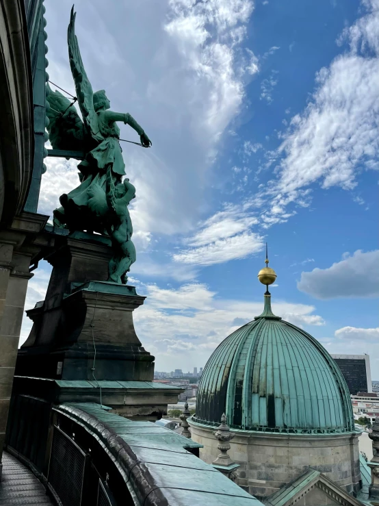 a statue of an angel on top of a building, by Tom Wänerstrand, pexels contest winner, viennese actionism, with great domes and arches, helmet view, slide show, overlooking