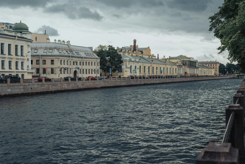 a river running through a city next to tall buildings, by Serhii Vasylkivsky, pexels contest winner, neoclassicism, overcast skies, saint petersburg, river flowing through a wall, listing image