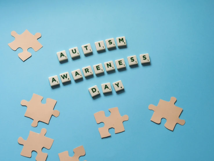 puzzle pieces spelling autism awareness day on a blue background, shutterstock, nfts, instagram picture, award - winning, ƒ/5.0