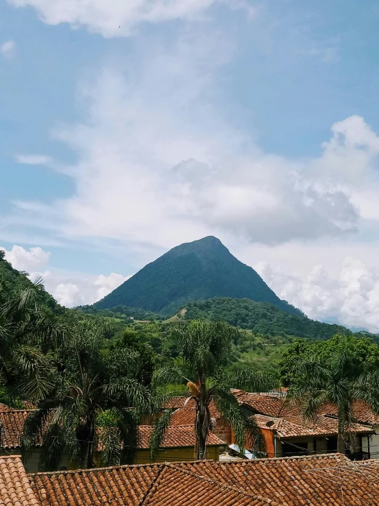 a view of a mountain from the roof of a building, by Carey Morris, sumatraism, tlaquepaque, background image, multiple stories, 8 k )