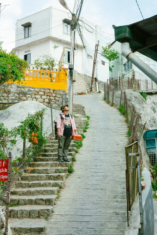 a person walking up a set of stairs, the village on the cliff, green alleys, kim doyoung, taken on a 2000s camera