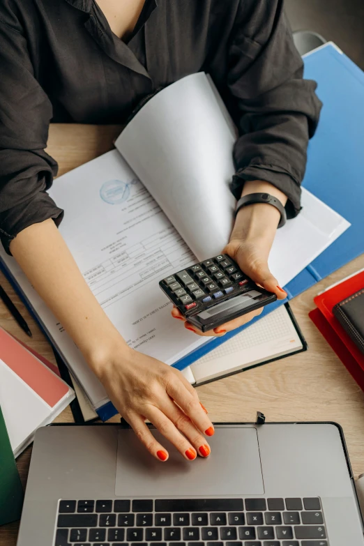 a woman sitting at a table with a laptop and a calculator, a digital rendering, trending on pexels, schools, curated collections, classic fantasy, bottom angle