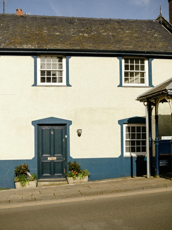 a white and blue house sitting on the side of a road, an album cover, unsplash, arts and crafts movement, stathmore 2 0 0, shop front, shepherd's crook, exterior view