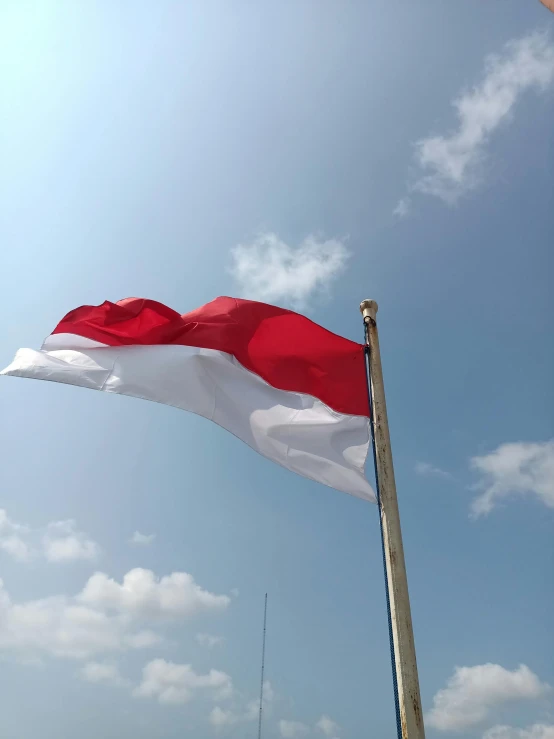 a large red and white flag flying in the air, trending on unsplash, hurufiyya, jakarta, avatar image, 🚿🗝📝, shot with iphone 1 0