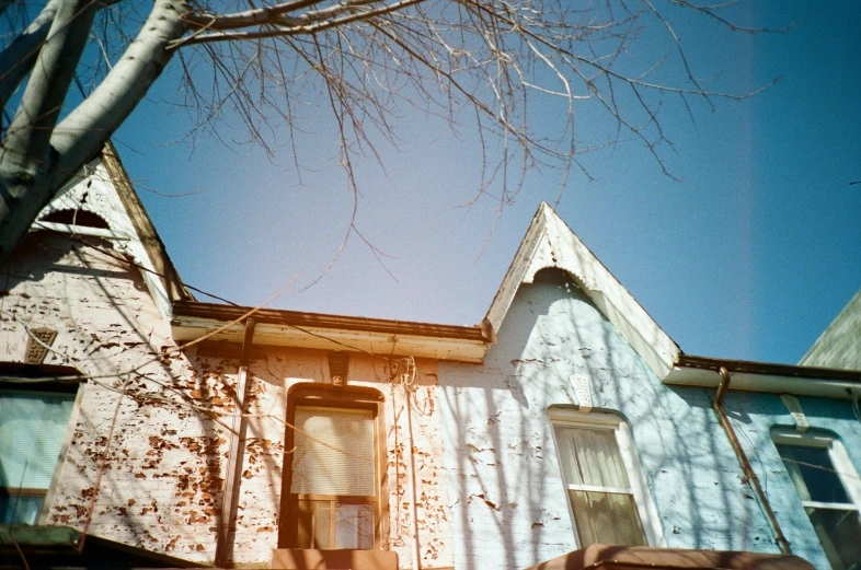 a couple of houses sitting next to each other, a polaroid photo, by Pamela Ascherson, unsplash, light blues, looking upwards, medium format film photography, midwest town