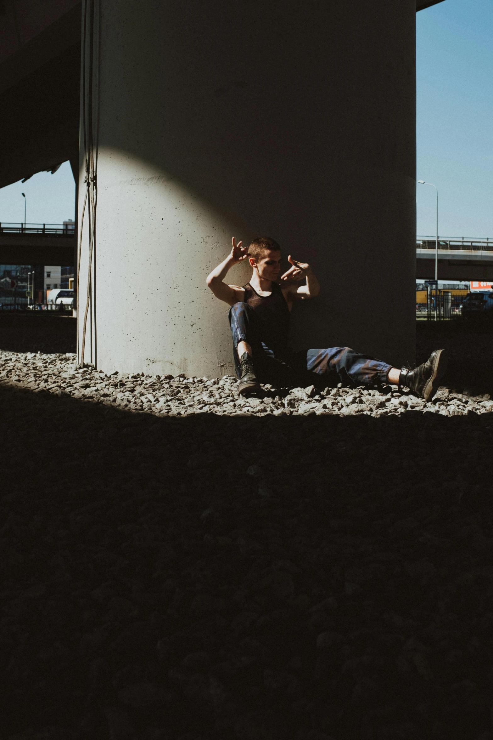 a person sitting on the ground under a bridge, a picture, unsplash, doing a sassy pose, 6 : 3 0 am, movie filmstill, high resolution photo