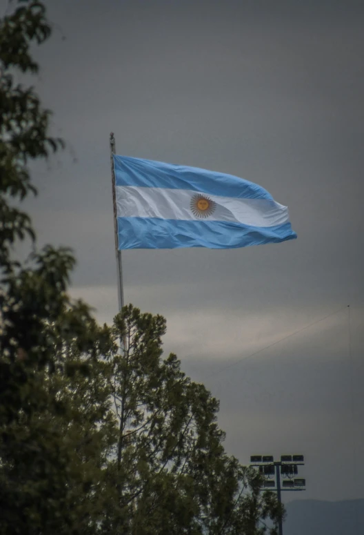 an argentinan flag flying high in the sky, a portrait, unsplash, hurufiyya, fujifilm”, americana, rear-shot, ( land )