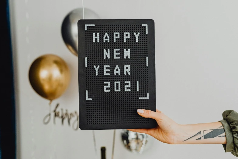 a person holding a sign that says happy new year level, a cross stitch, by Julia Pishtar, trending on pexels, infinity mirror, background image, black, 3 2 x 3 2