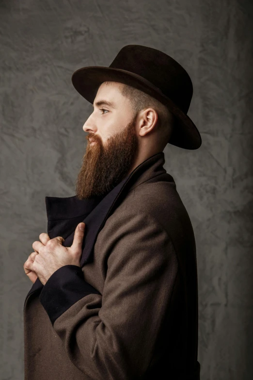 a man with a beard wearing a hat and coat, brown buzzcut, elegant profile pose, full colour, bushy beard