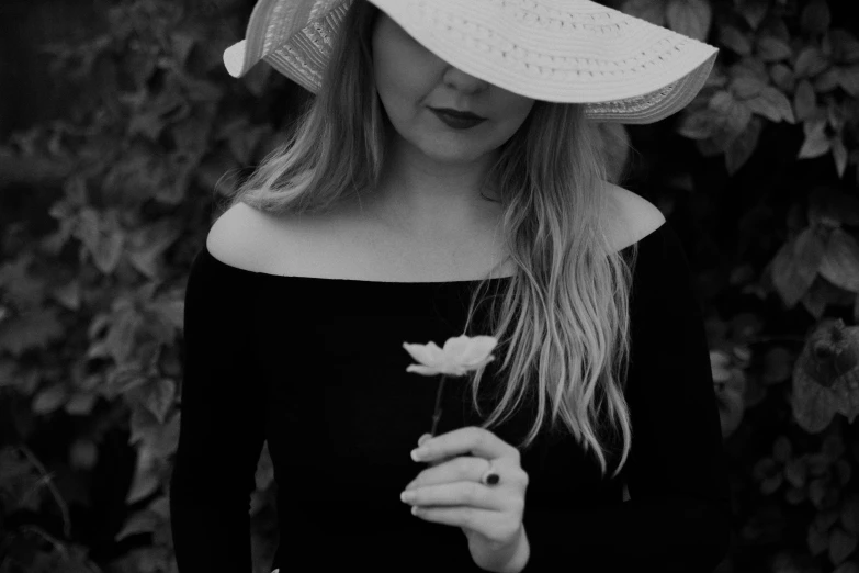 a woman wearing a hat and holding a flower, a black and white photo, by Caroline Mytinger, pexels contest winner, young blonde woman, 15081959 21121991 01012000 4k, white petal, datura