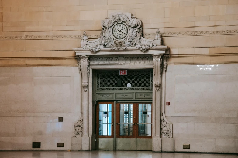 a large building with a clock on the front of it, a marble sculpture, by Carey Morris, pexels contest winner, symmetrical doorway, mta subway entrance, professional woodcarving, moody : : wes anderson