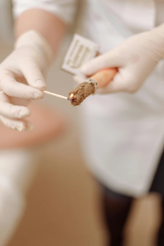 a close up of a person putting food on a skewer, by Jakob Gauermann, pathology, holding cigar, production photo, poop