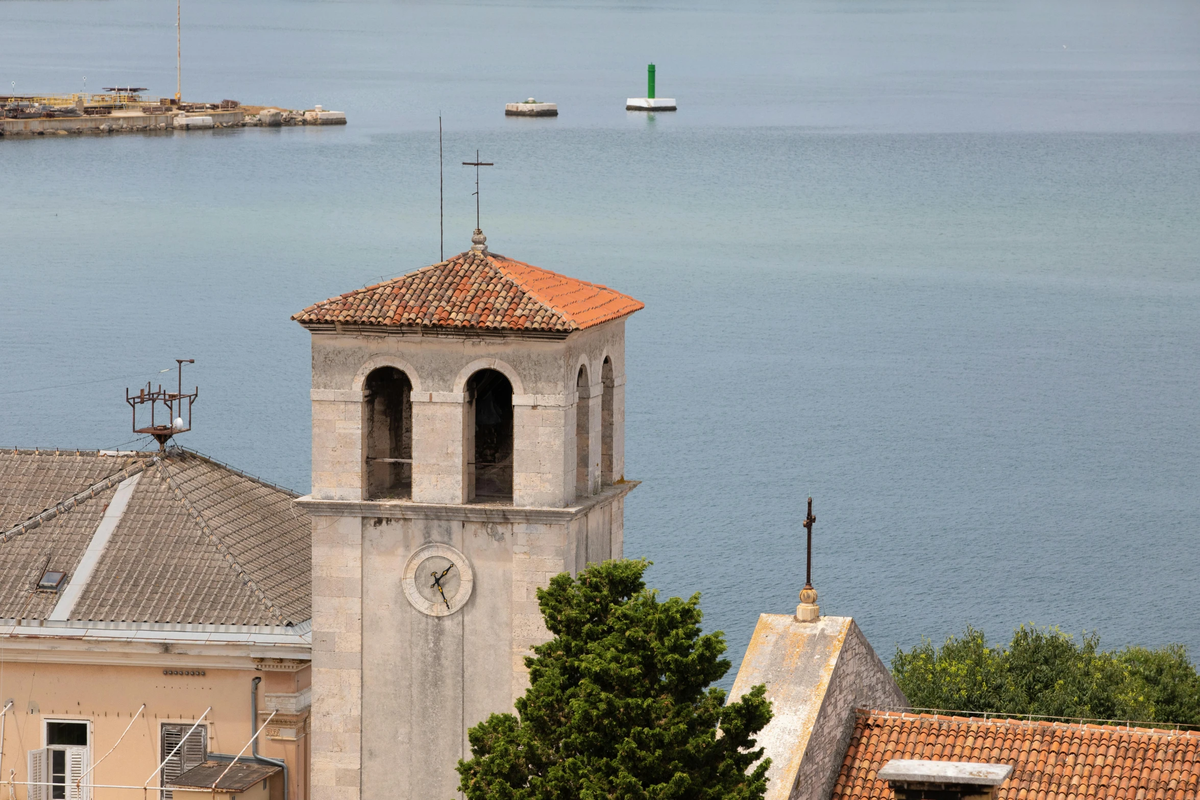 a clock tower on top of a building next to a body of water, romanesque, seaview, distant photo, saint womans, limestone