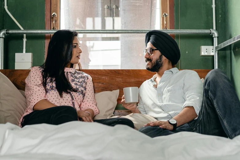 a man and a woman sitting on a bed, inspired by Manjit Bawa, pexels, in chippendale sydney, talking, caps sideways, morning coffee