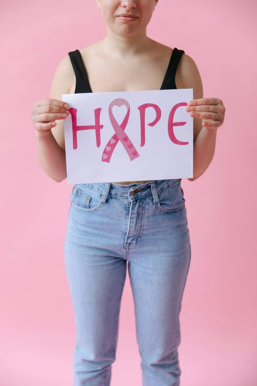 a woman holding a sign that says hope, a photo, trending on pexels, pink body, white ribbon, diagnostics, hip-length
