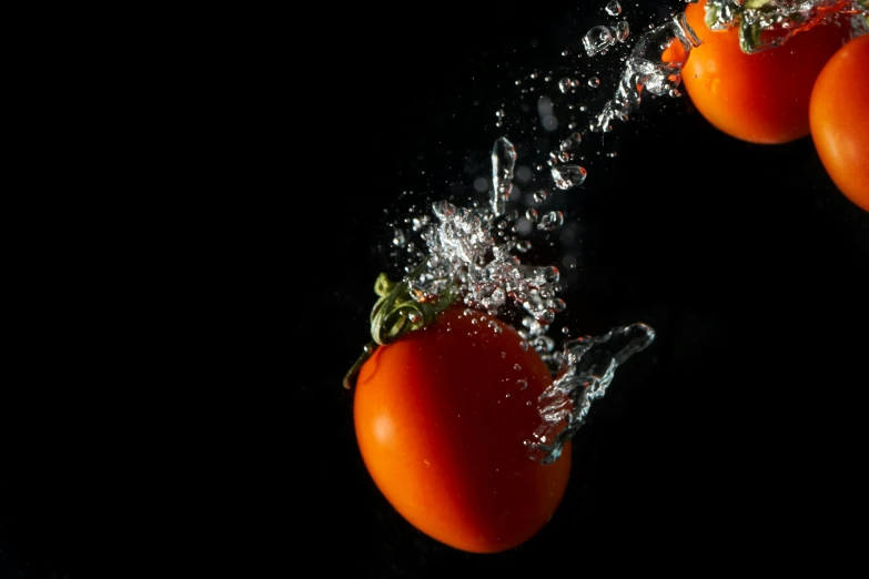 a bunch of tomatoes falling into the water, by Tom Bonson, unsplash, with a black background, shot on sony a 7, farming, looking left