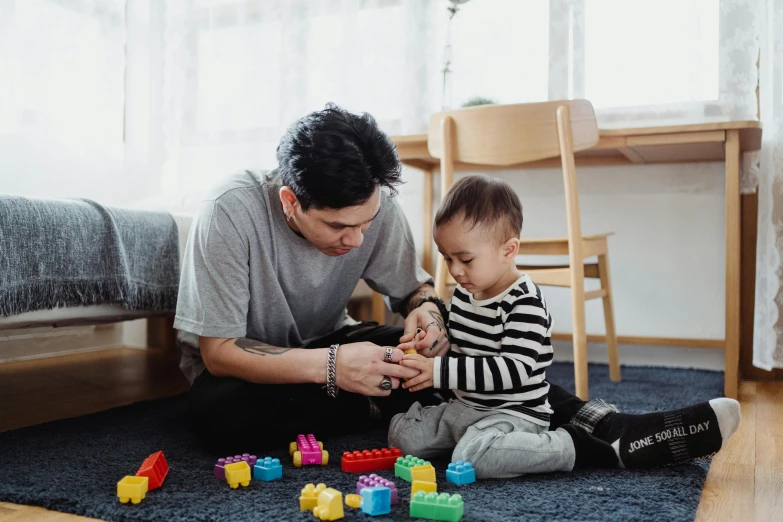 a man playing with a child on the floor, pexels contest winner, building blocks, avatar image, asian male, worksafe. instagram photo