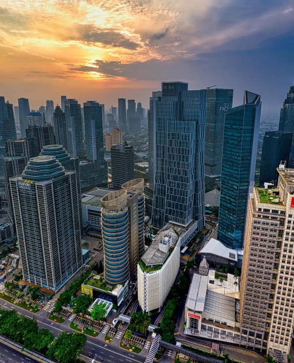 an aerial view of a city at sunset, by Erik Pevernagie, pexels contest winner, happening, jakarta, square, background image, skyscrapers with greenery