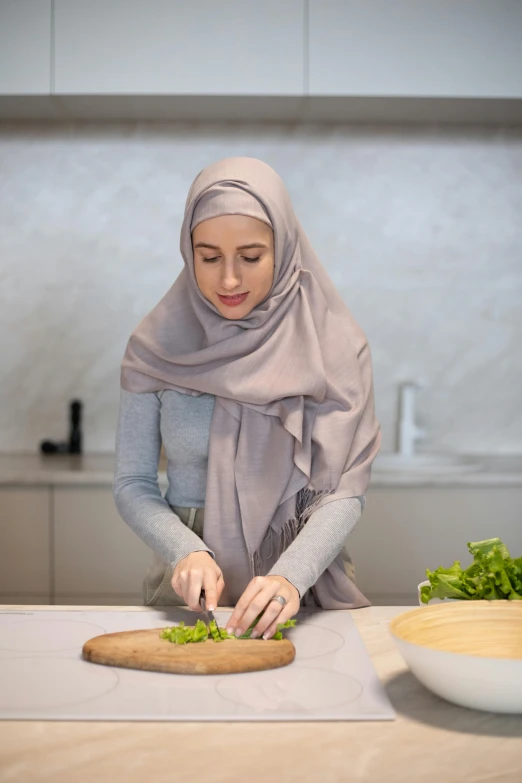 a woman in a hijab cutting vegetables on a cutting board, inspired by Nazmi Ziya Güran, hurufiyya, light grey, lettuce, null, plating