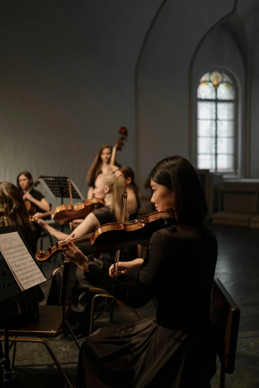 a group of people playing musical instruments in a room, an album cover, unsplash, baroque, asian women, in church, [ cinematic, cinematic shot ar 9:16 -n 6 -g