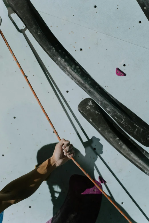 a man on a climbing wall holding onto a rope, an album cover, unsplash, renaissance, longbow arrow, vessels, low quality photo, aerial shot