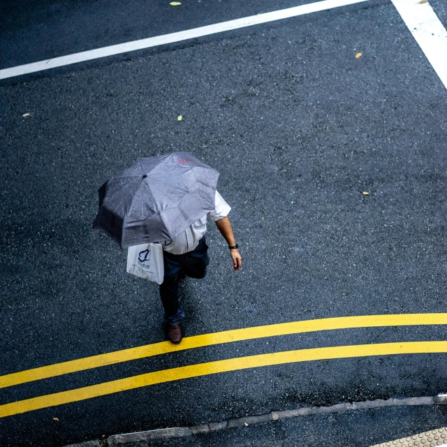 a man walking down a street holding an umbrella, pexels contest winner, yellow and charcoal, top-down shot, shot on sony a 7, rectangle