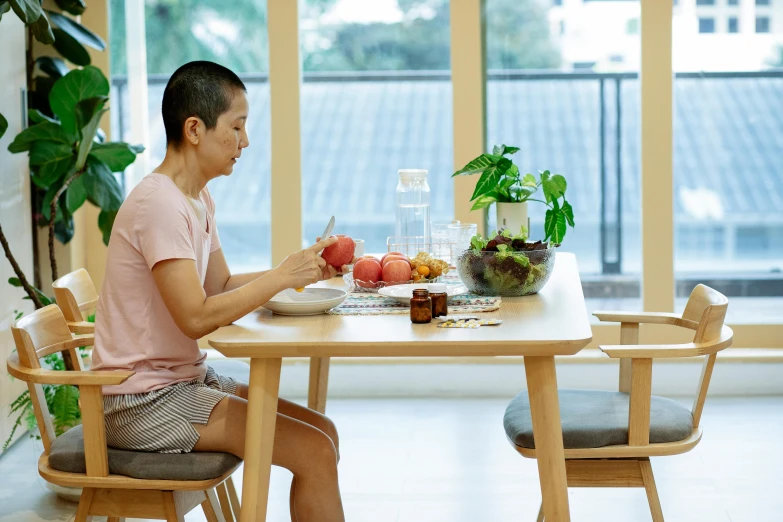 a man sitting at a table with a plate of food, by Jang Seung-eop, pexels contest winner, she is easting a peach, relaxed posture, profile image, at home