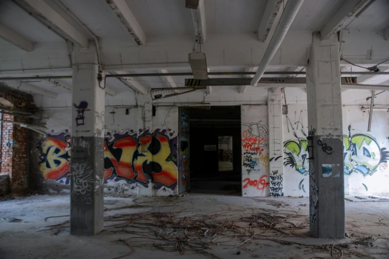 a room with lots of graffiti on the walls, concrete building, desolate, indoor picture