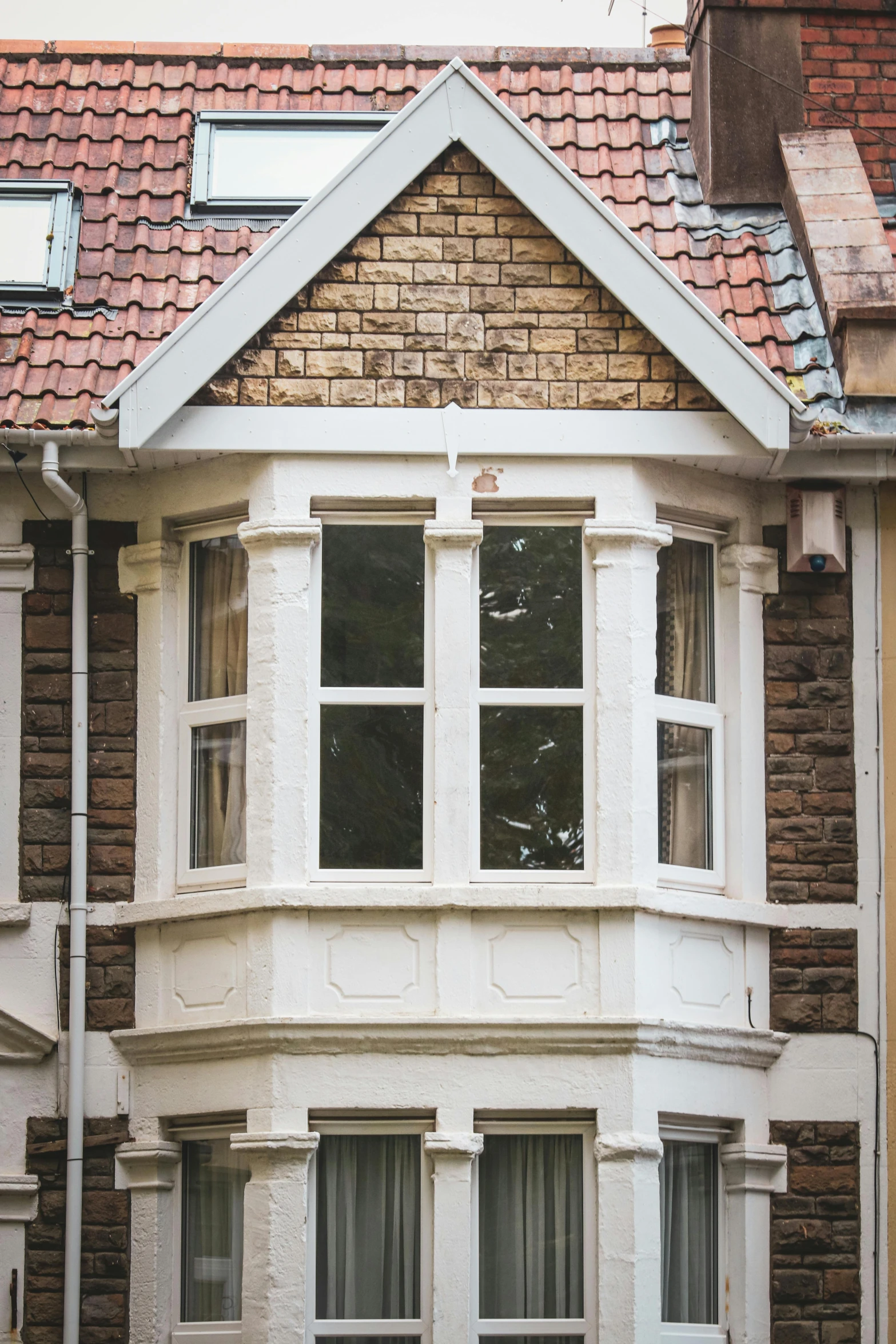 a red fire hydrant sitting in front of a brick building, by Rachel Reckitt, unsplash, sunny bay window, built into trees and stone, interior of a victorian house, tiled roofs