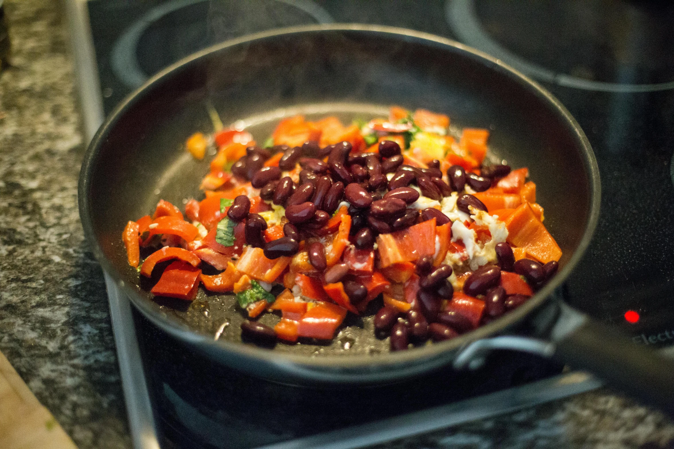 a frying pan filled with vegetables on top of a stove, by Carey Morris, pexels, beans, mexican, red and orange colored, eating