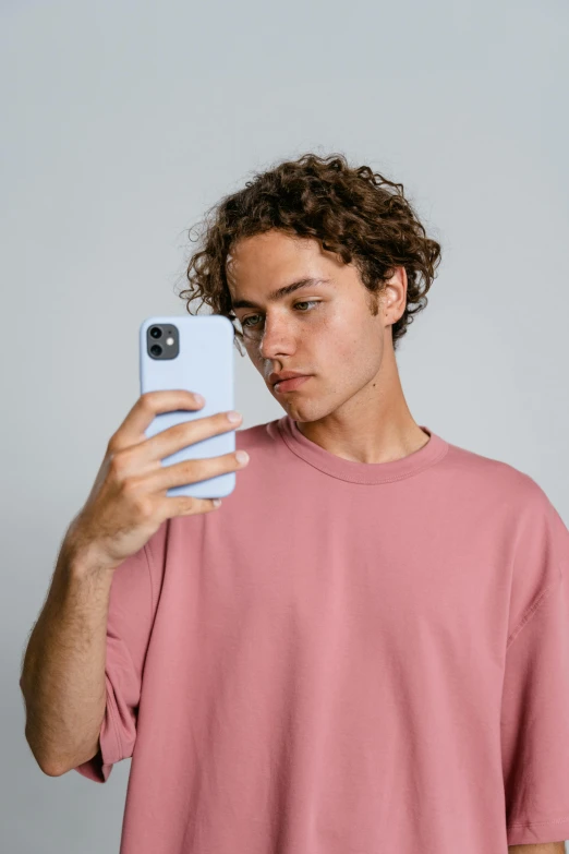 a man taking a selfie with his cell phone, trending on pexels, renaissance, minimal pink palette, boy with neutral face, curls on top, tight shirt