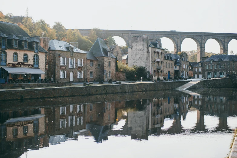 a river running through a town next to a bridge, a photo, pexels contest winner, les nabis, still water calm as a mirror, tall arches, notan, gray