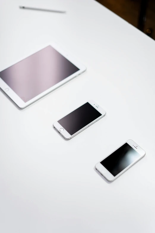 a group of cell phones sitting on top of a white table, a picture, by Jang Seung-eop, minimalism, 9 9 designs, white pearlescent, took on ipad, no - text no - logo
